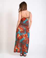 Woman wearing a tie-dye dress with red, blue, and green patterns on a white background